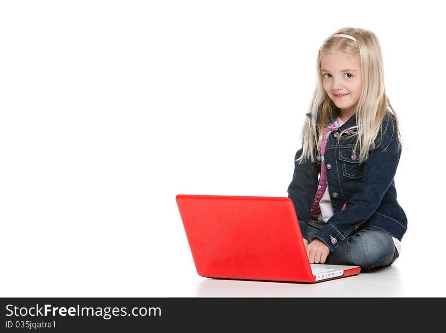 Cute little girl sitting down using a laptop isolated on white background. Cute little girl sitting down using a laptop isolated on white background