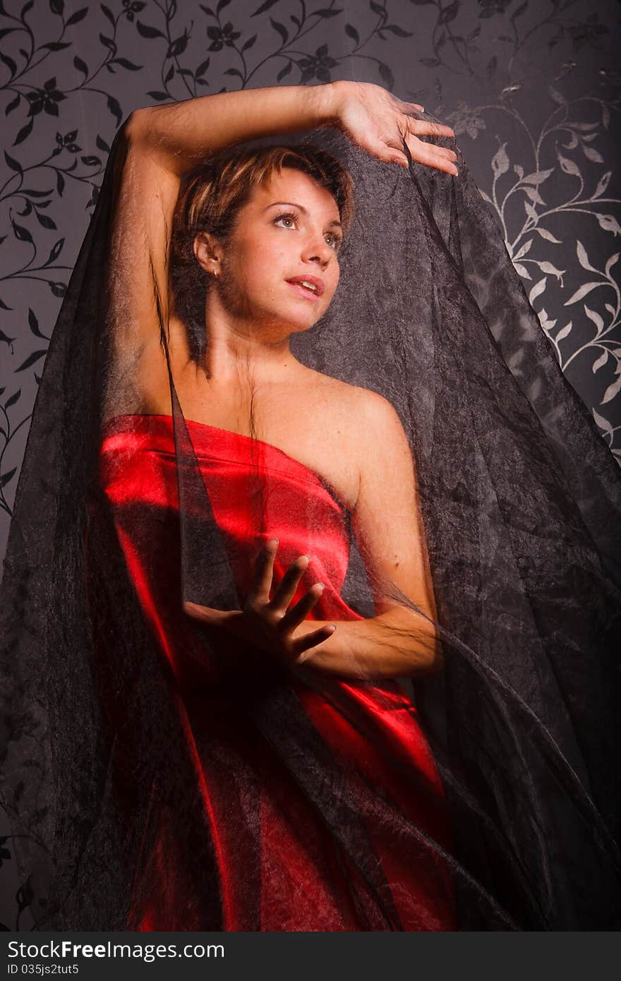 Beautiful young woman in a red dress with a delicate shawl. Beautiful young woman in a red dress with a delicate shawl