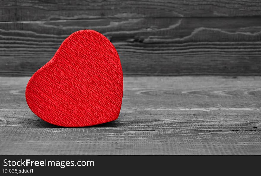 Red box in heart shape on wood background