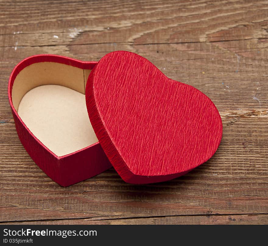 Red box in heart shape on wood background