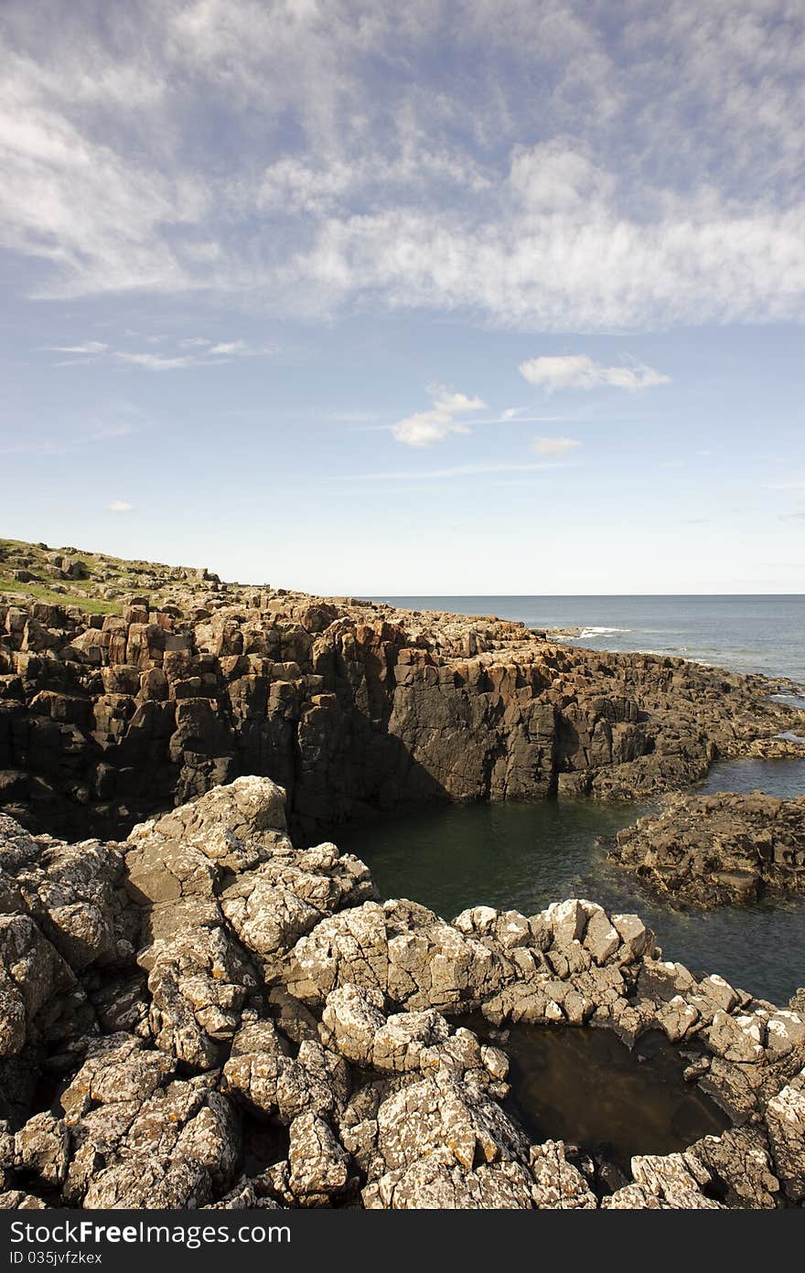 Photograph of a typical, rocky coastal summer scene on the Northumberland coast, England. Photograph of a typical, rocky coastal summer scene on the Northumberland coast, England.