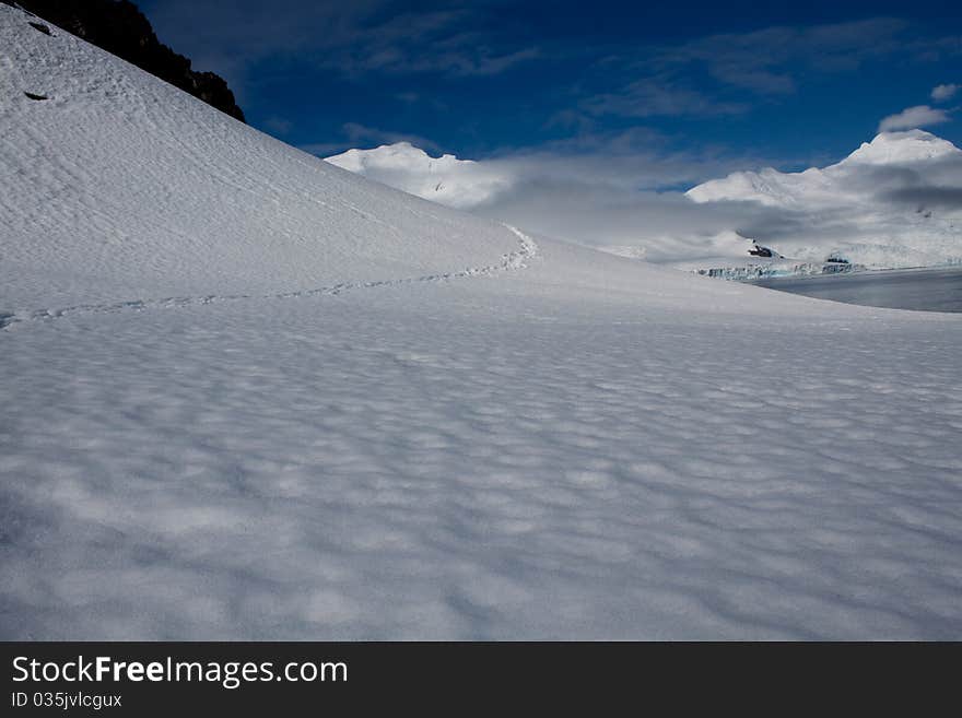 A trail leads through a snowy scene in Antarctica. A trail leads through a snowy scene in Antarctica