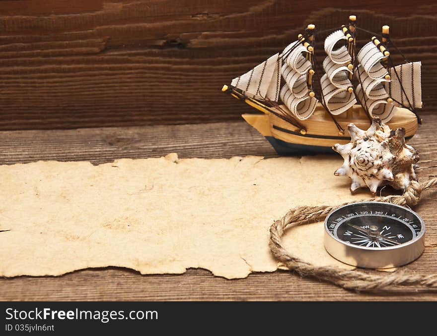 Old paper and model classic boat on wood background