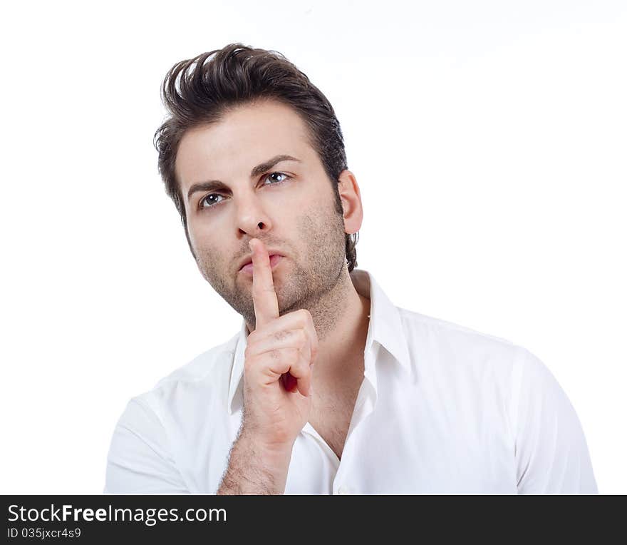 Man in white shirt doing a silence gesture with forefinger - isolated on white. Man in white shirt doing a silence gesture with forefinger - isolated on white