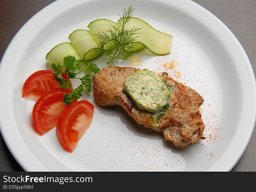 Grilled meat with vegetables in butter dish