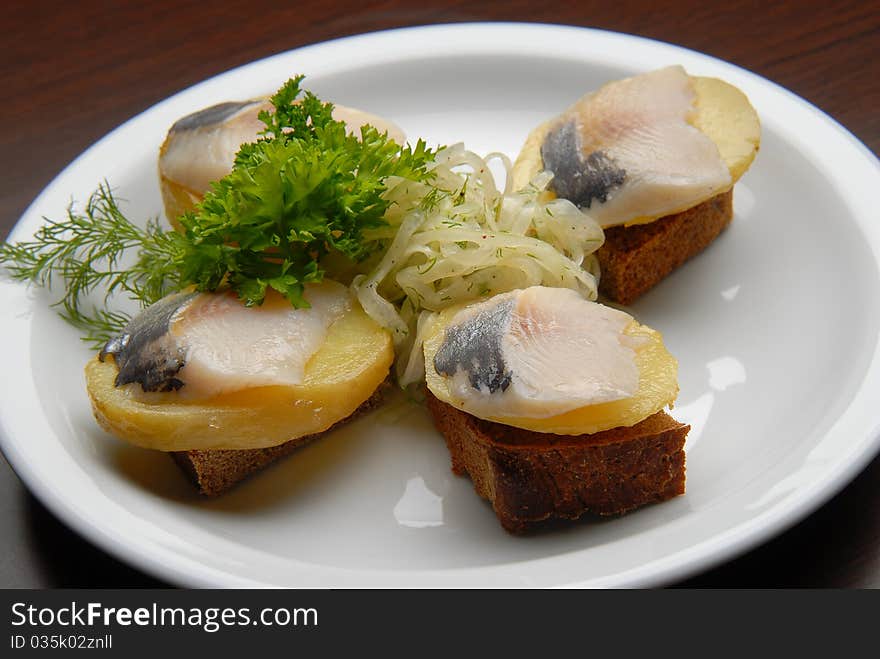 snacks with salt fish, potatoes and onions on bread. snacks with salt fish, potatoes and onions on bread