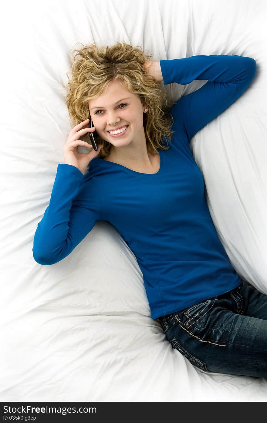 Cute teenage girl lying down talking on phone