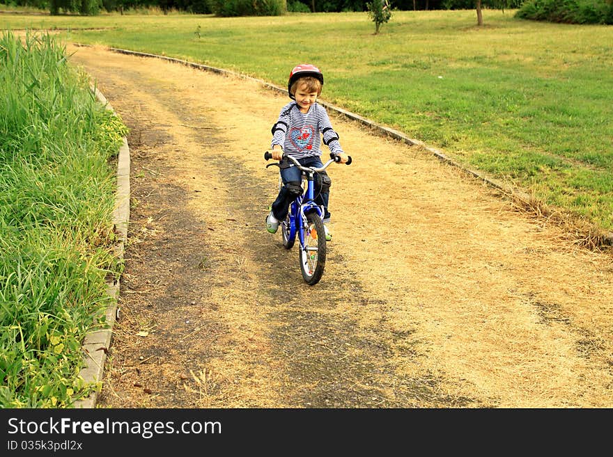 A little girl rides a bike in the park.