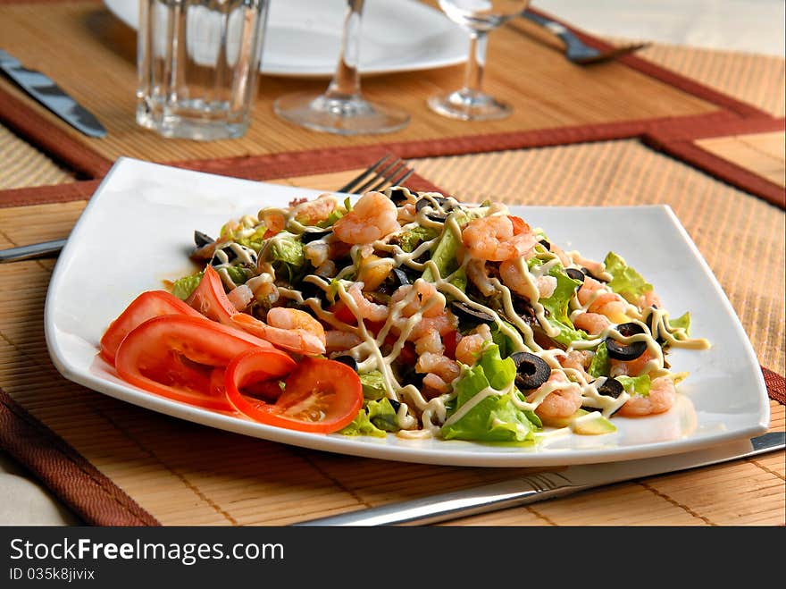 Shrimp salad with vegetables and sauce on a plate