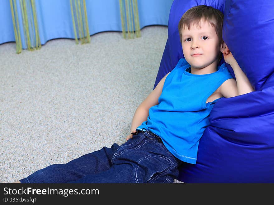 Little smiling boy is playing on a floor at home.