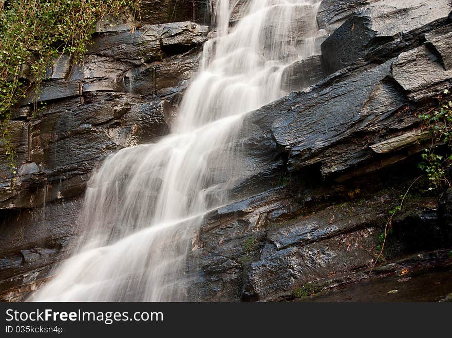 The side view of a waterfall over rocks and nature. The side view of a waterfall over rocks and nature