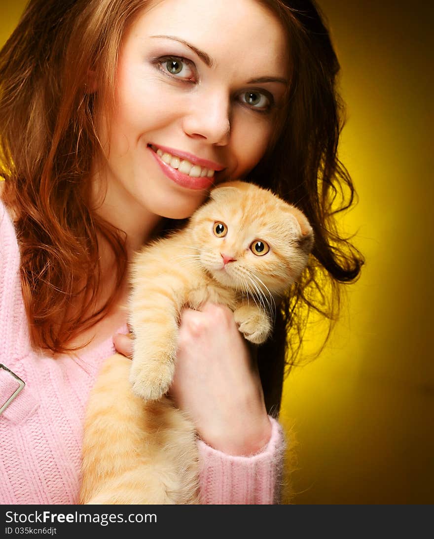 Young woman with red England lop-eared kitten