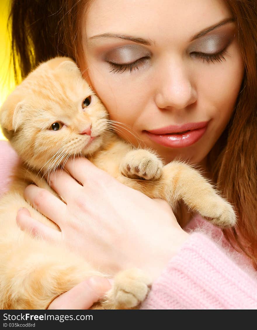 Young woman with red England lop-eared kitten