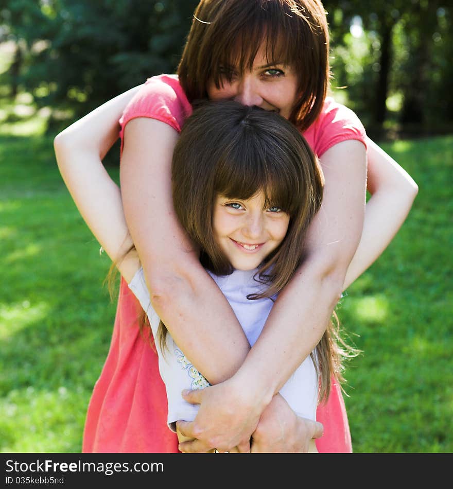 Mother and daughter smiling outdoor.