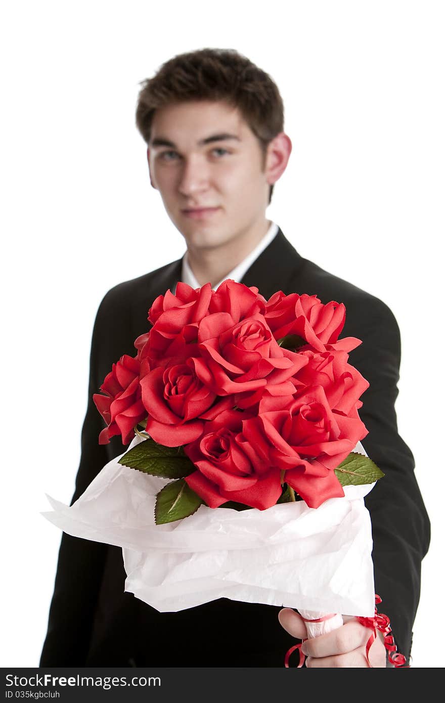 Attractive teenage boy wearing a suit holding a bouquet of fabric roses isolated on white background. Attractive teenage boy wearing a suit holding a bouquet of fabric roses isolated on white background