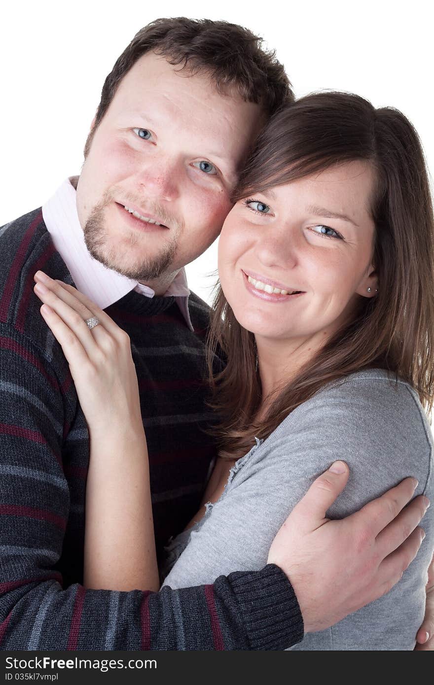 Portrait of a beautiful young couple hugging each other against white background