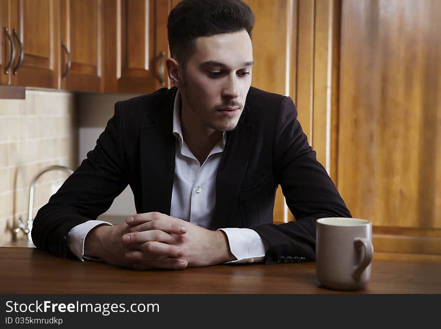 Man Sitting At The Kitchen Counter