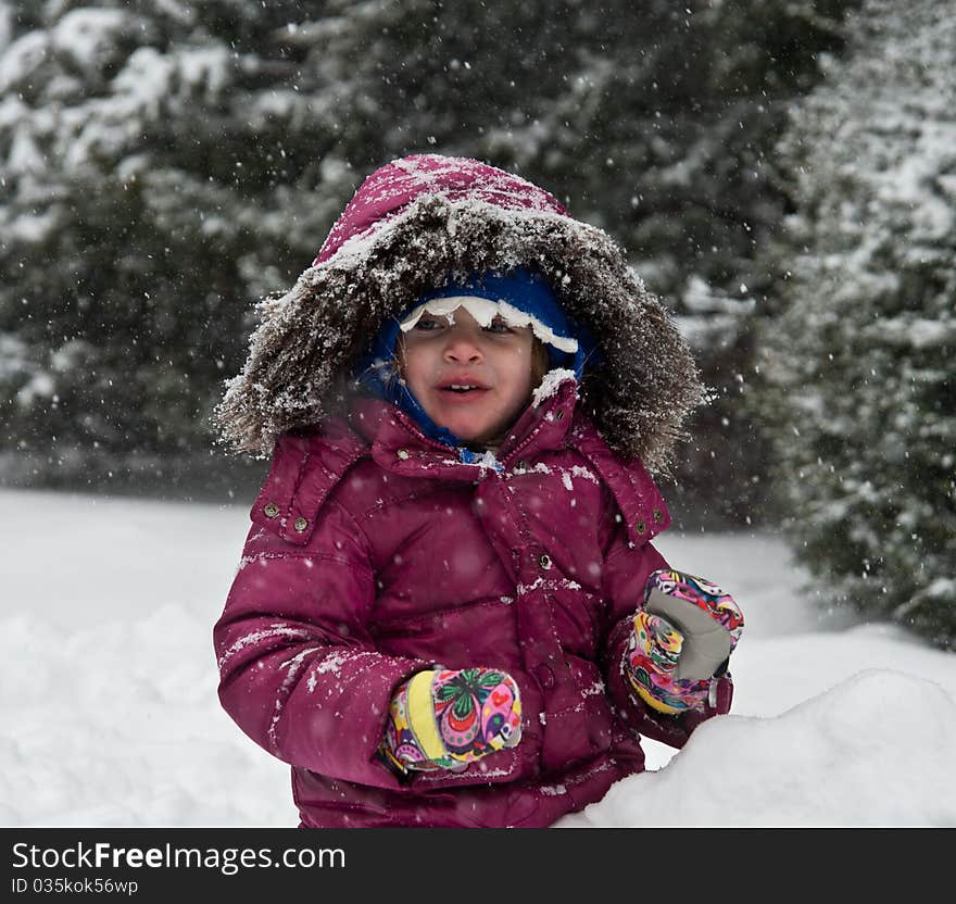 Little Girl Playing In The Snow. Little Girl Playing In The Snow