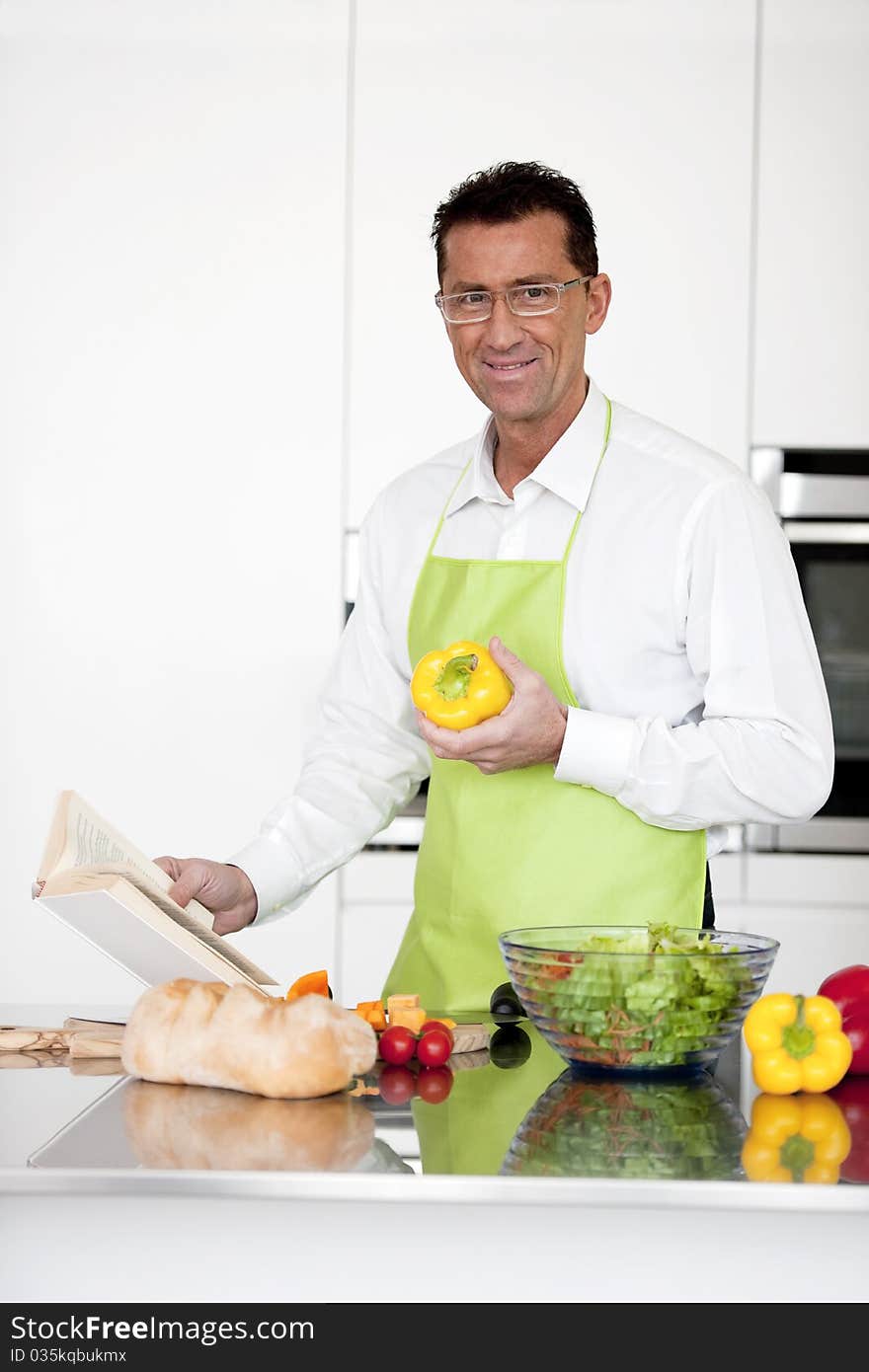 Mature man preparing food in his kitchen. Mature man preparing food in his kitchen