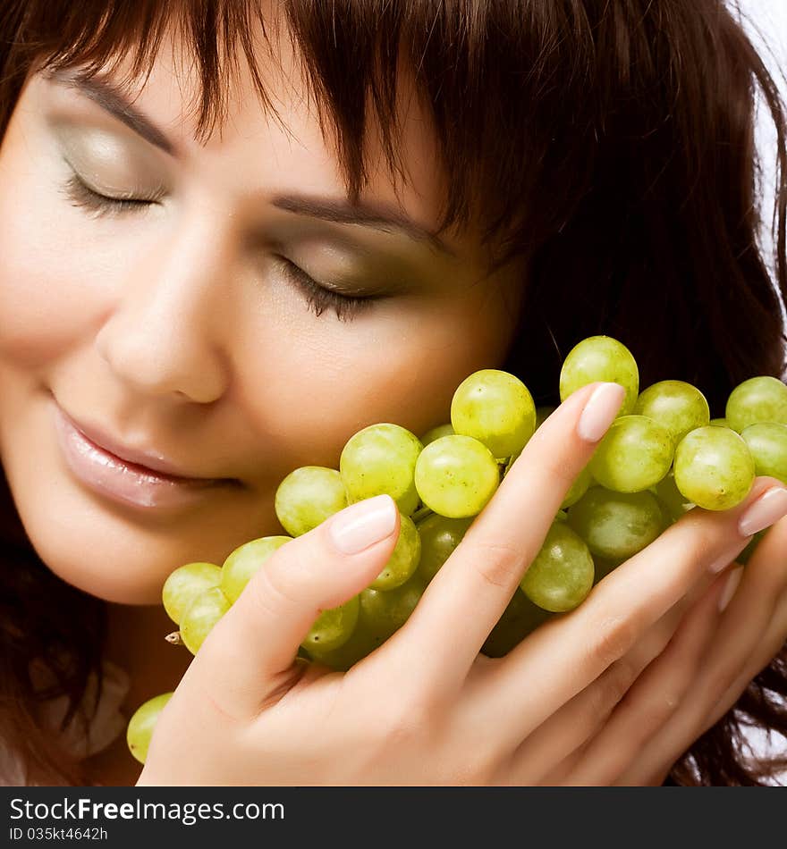 Portrait of young woman with green grapes