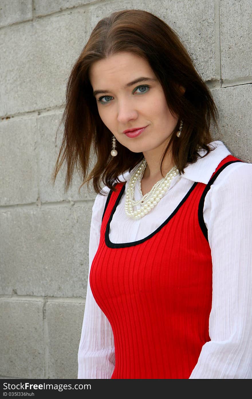 Woman in red standing leaning against the wall. Woman in red standing leaning against the wall