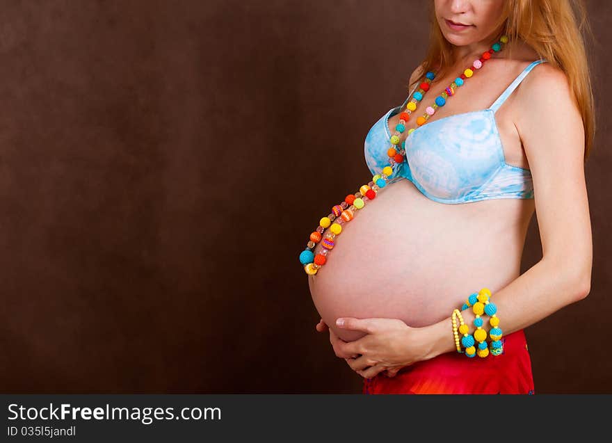 Pregnant young woman in colorful crocheted necklace