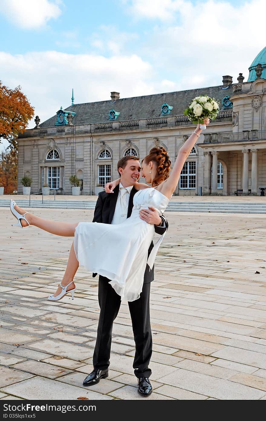 The happy young couple. Groom holding bride in his arms. The happy young couple. Groom holding bride in his arms.