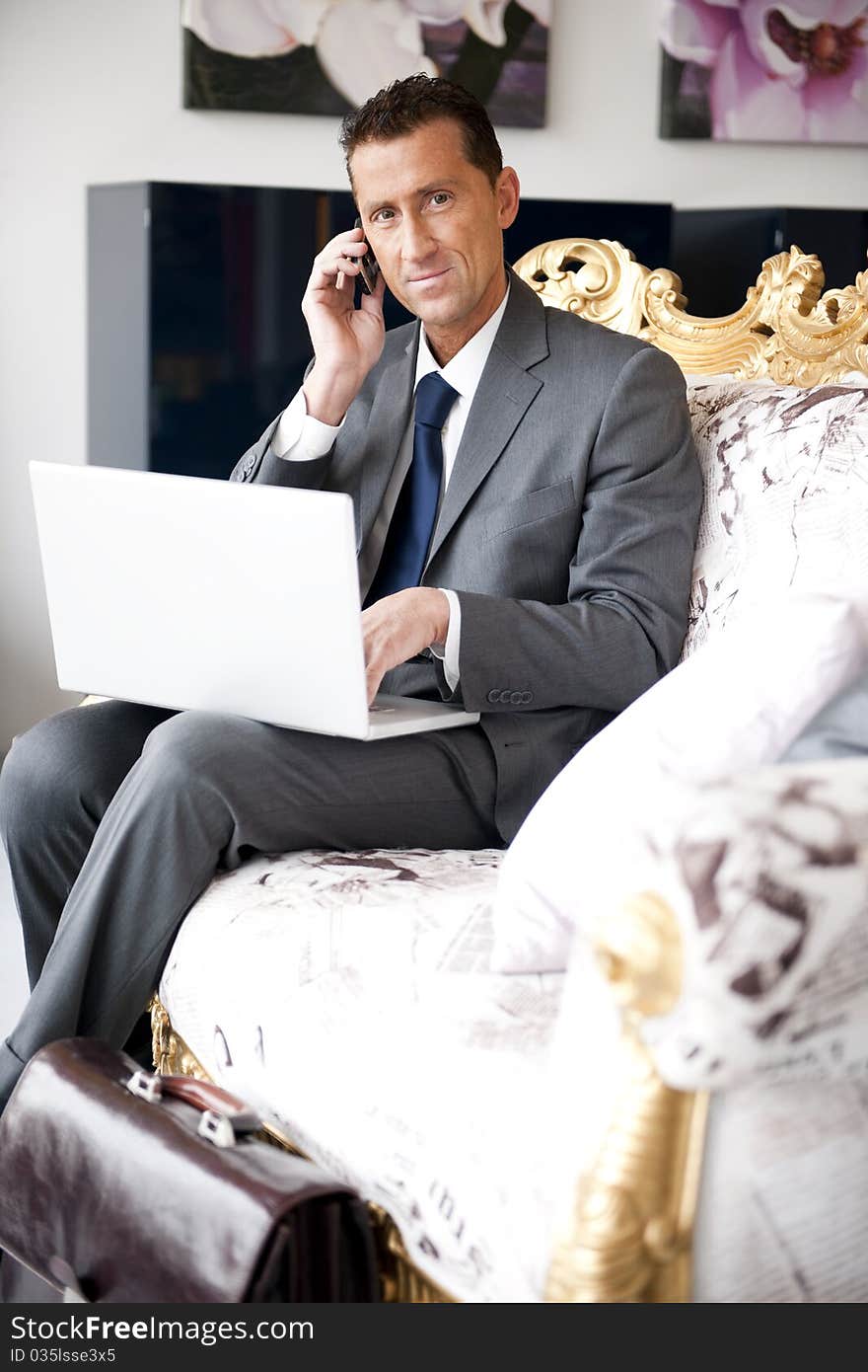 Businessman working while sitting on a vintage sofa. Businessman working while sitting on a vintage sofa