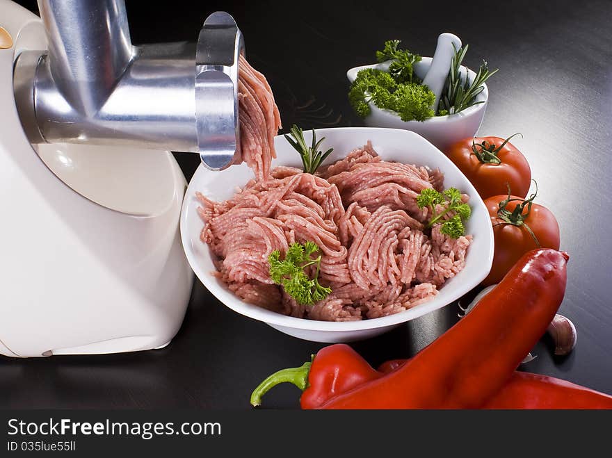 Bowl of mince with electric meat grinder and vegetables. Bowl of mince with electric meat grinder and vegetables