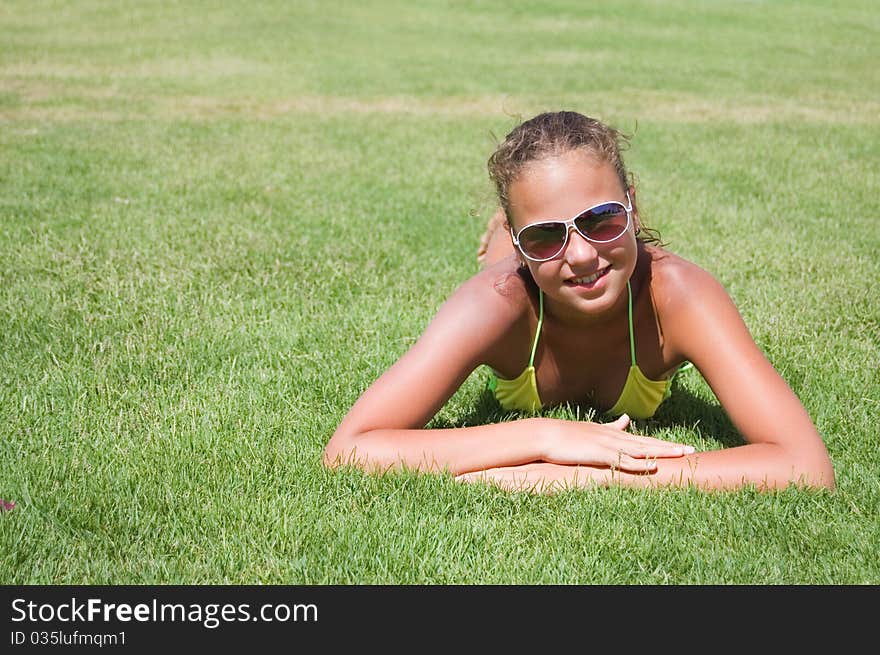 The young girl lays on a grass