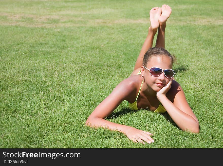 The young girl lays on a grass