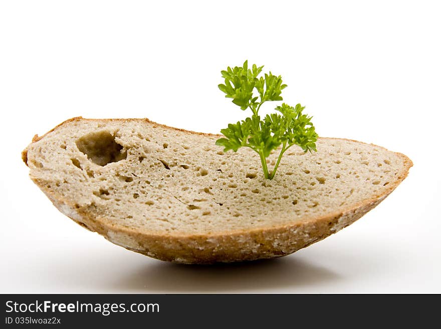 Fresh bread cut with parsley onto white background. Fresh bread cut with parsley onto white background