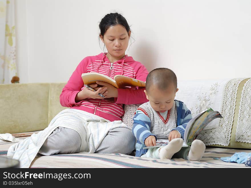 A chinese family, the mother and the boy are reading the book in home. A chinese family, the mother and the boy are reading the book in home.