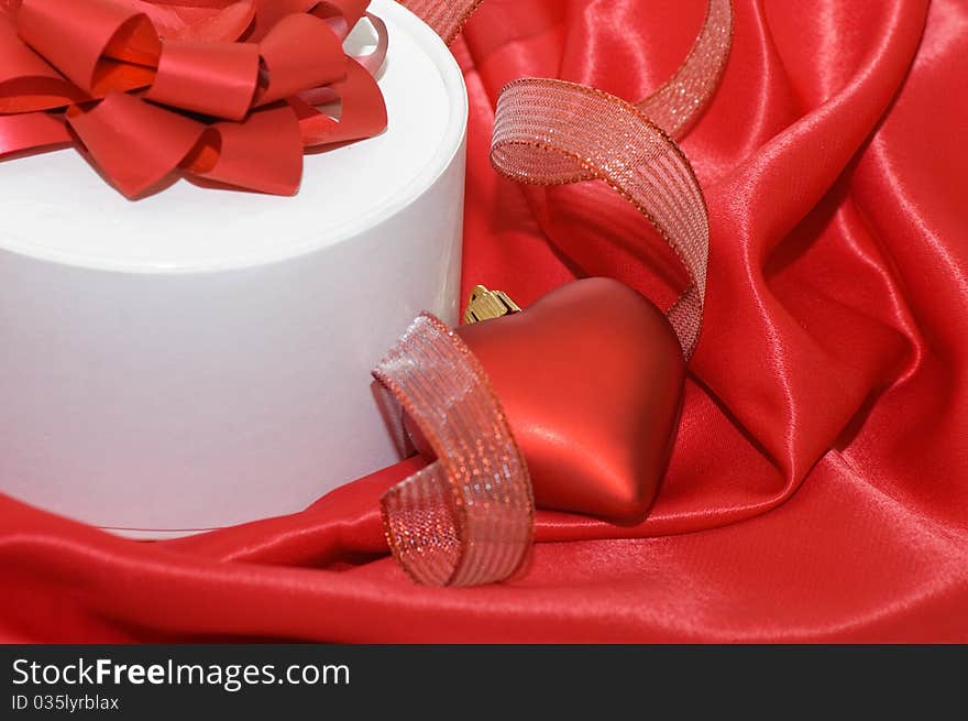 Box with a gift on a red fabric still life