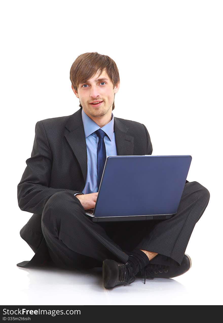 Happy young business man working on a laptop, isolated against white background