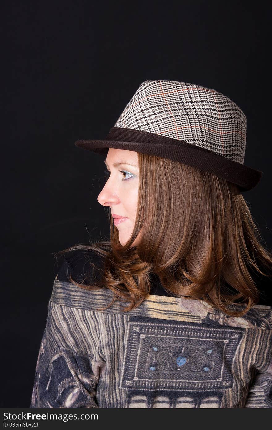 Charming young woman in a hat on black background. Charming young woman in a hat on black background