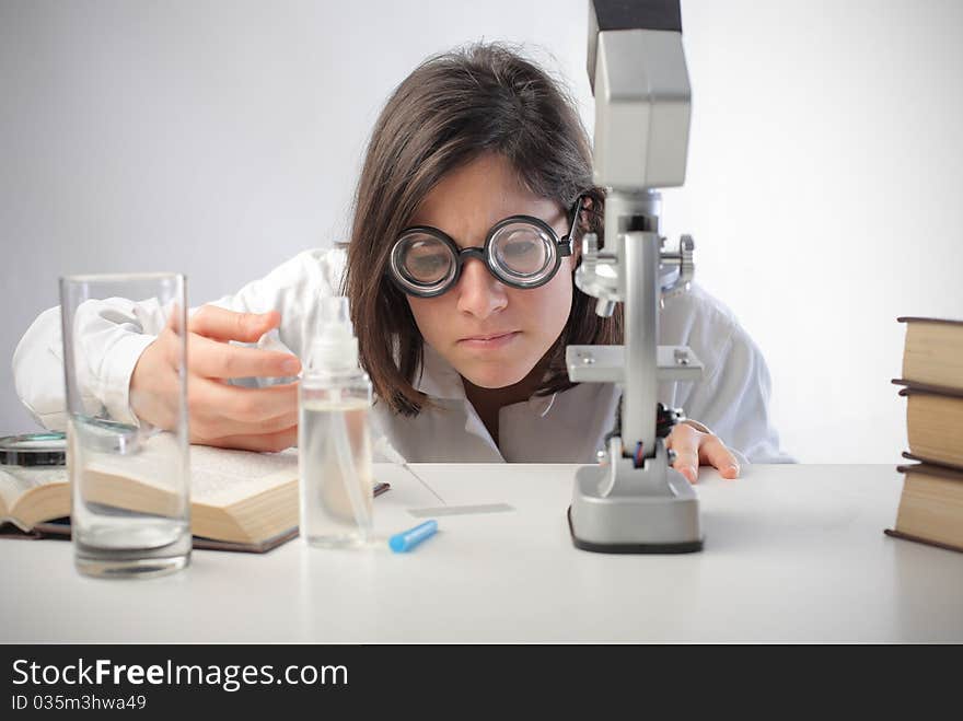 Young scientist analysing a substance on a microscope slide. Young scientist analysing a substance on a microscope slide