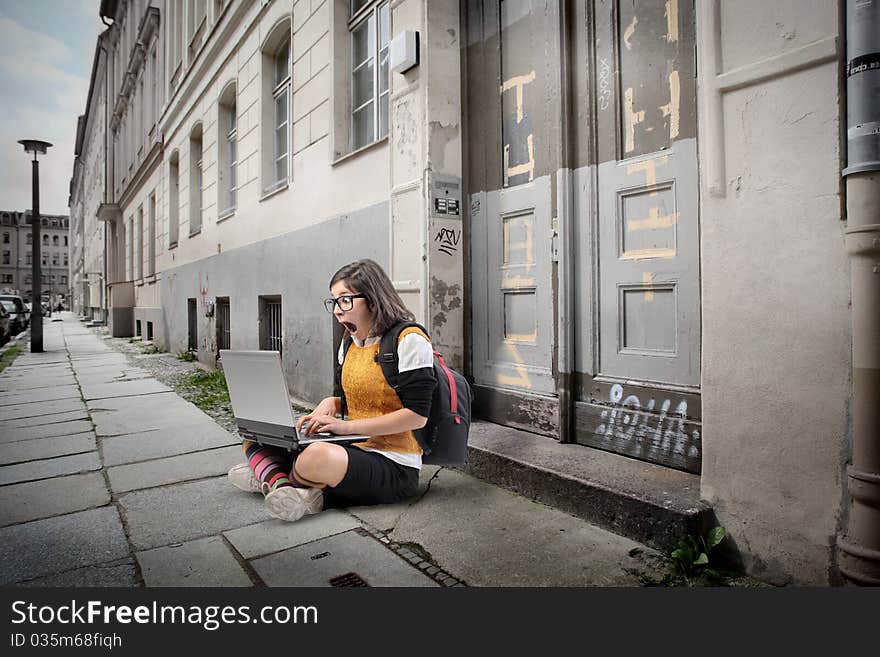 Amazed student using a laptop on a city street. Amazed student using a laptop on a city street