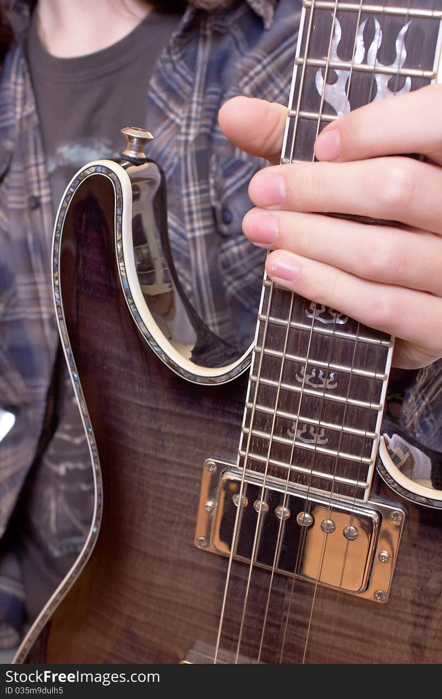 Guitarist holding his guitar by the neck