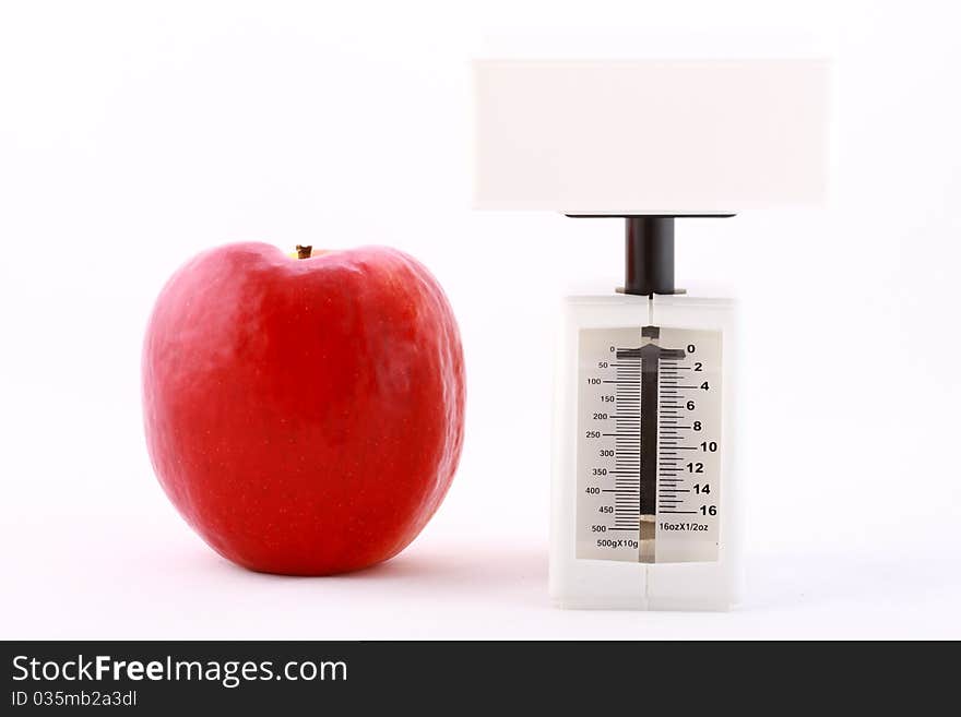 Dietic concept: red apple and white balance isolated on white