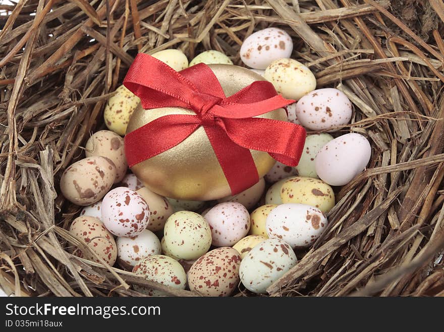 Golden easter eggs in bird nest over white