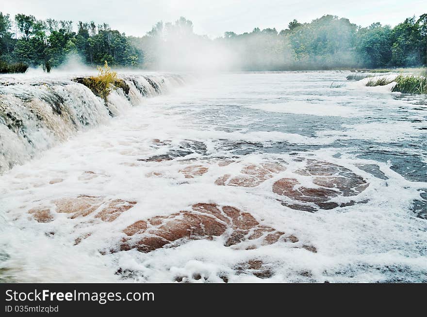 Mist above river, natural waterfall.