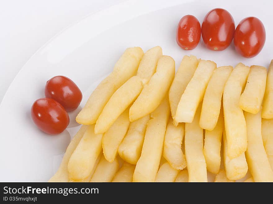 The fried potato is laid out in a plate with tomatoes. The fried potato is laid out in a plate with tomatoes.