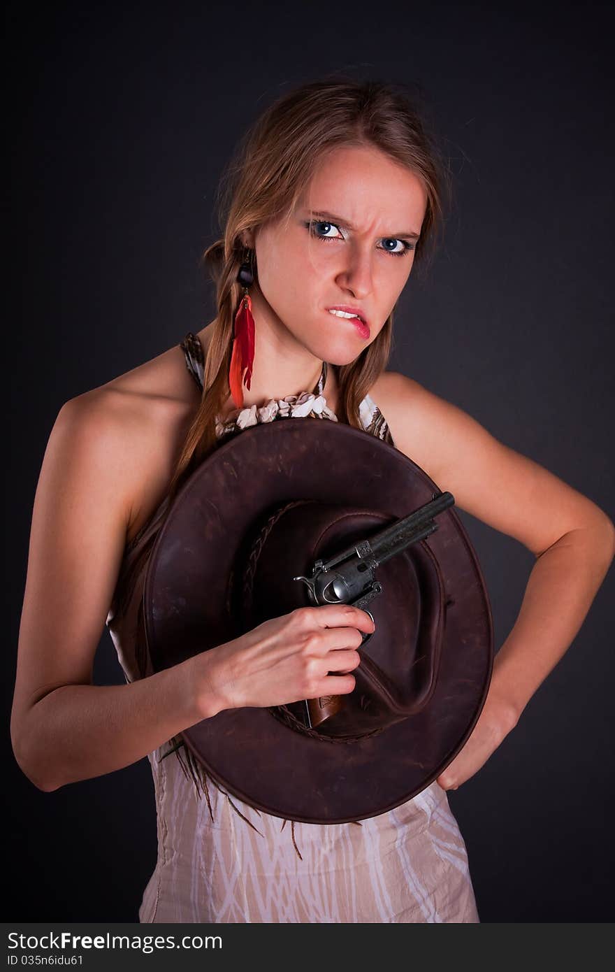 The American Indian girl with a cowboy's hat holds a pistol