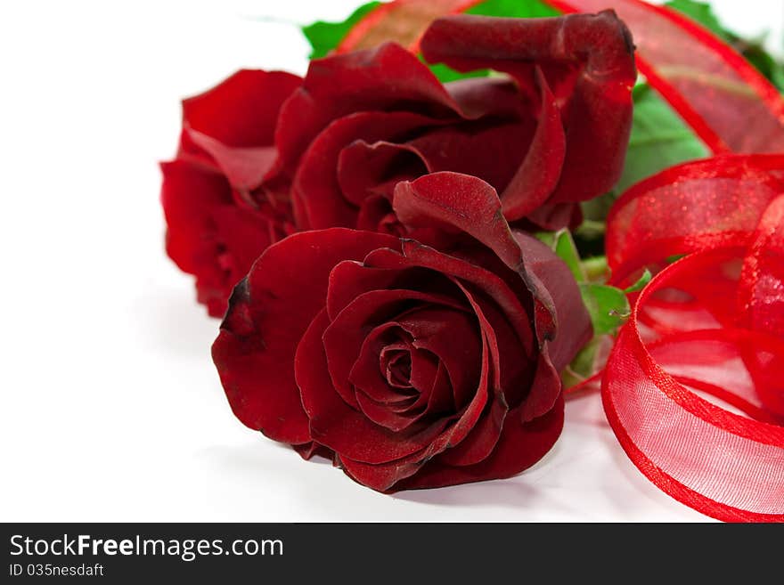 Red roses isolated on white background with red ribbon around it. Red roses isolated on white background with red ribbon around it.