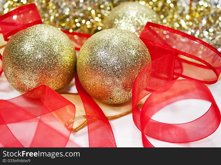 Golden christmas balls with red ribbon in white background for christmas eve