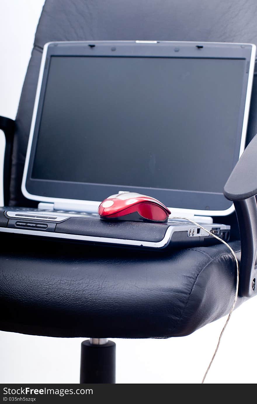 Business chair with laptop, glasses and mouse