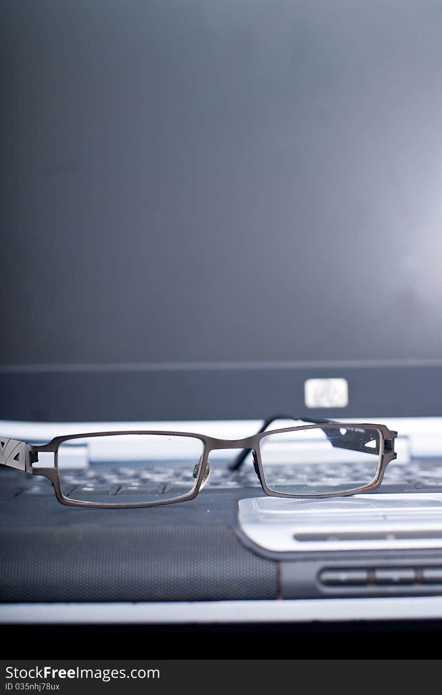 Business laptop with glasses in focus. Business laptop with glasses in focus