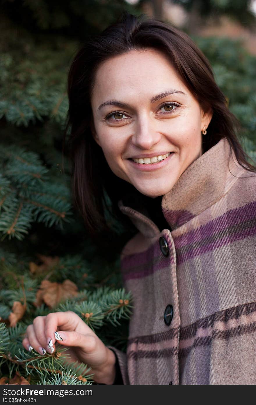 Beautiful young woman near firtree in autumn. Beautiful young woman near firtree in autumn