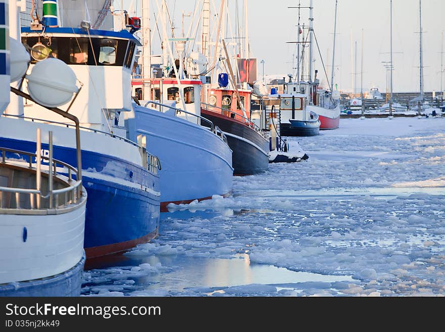 Fishing boats at dock in a frozen winter sea. Fishing boats at dock in a frozen winter sea